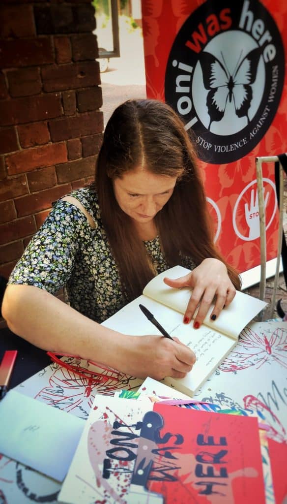 Antonia Squara survivor of gender based violence signs book
